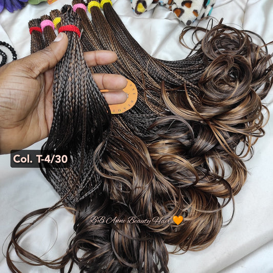 Braided hair extensions held by a hand with a blurred background