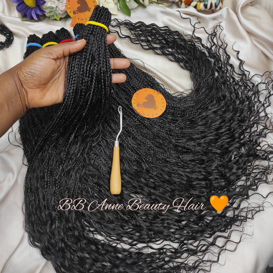 Black braided hair extensions with a crochet hook on a white fabric background, branded 'BB Anne Beauty Hair'.