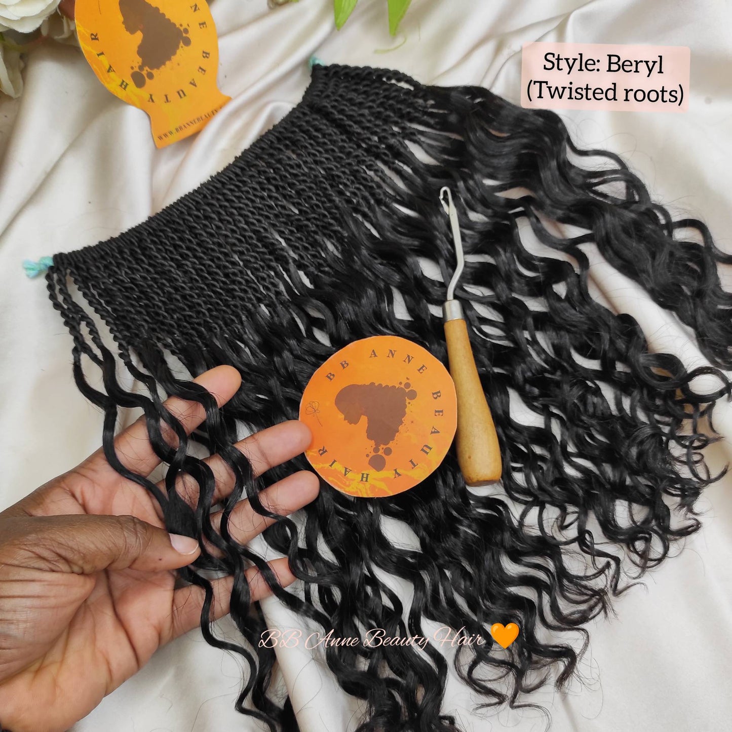 Black braided human hair extensions with twisted roots held by a hand, branded 'bb anne Beauty Hair'.