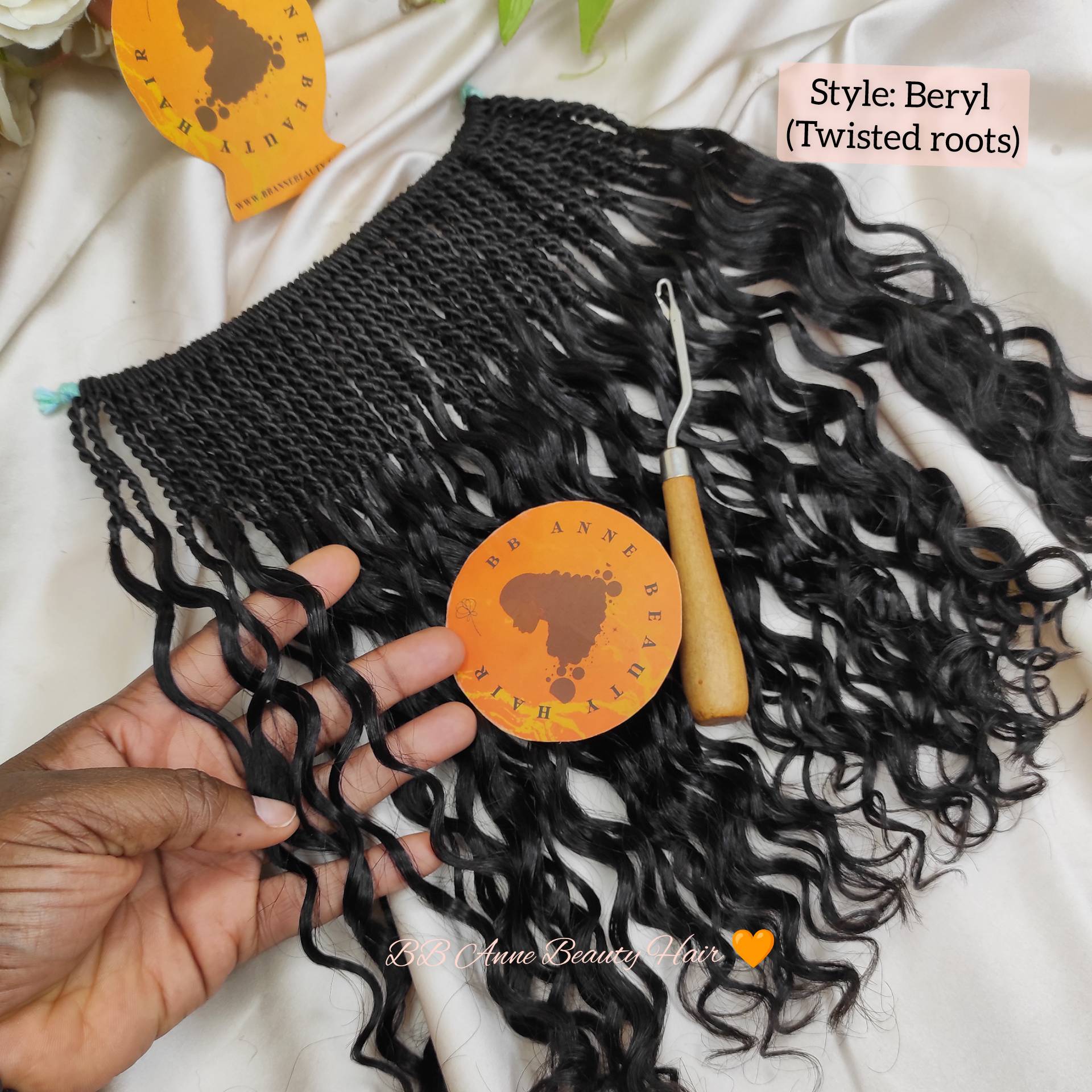 Black braided human hair extensions with twisted roots held by a hand, branded 'bb anne Beauty Hair'.