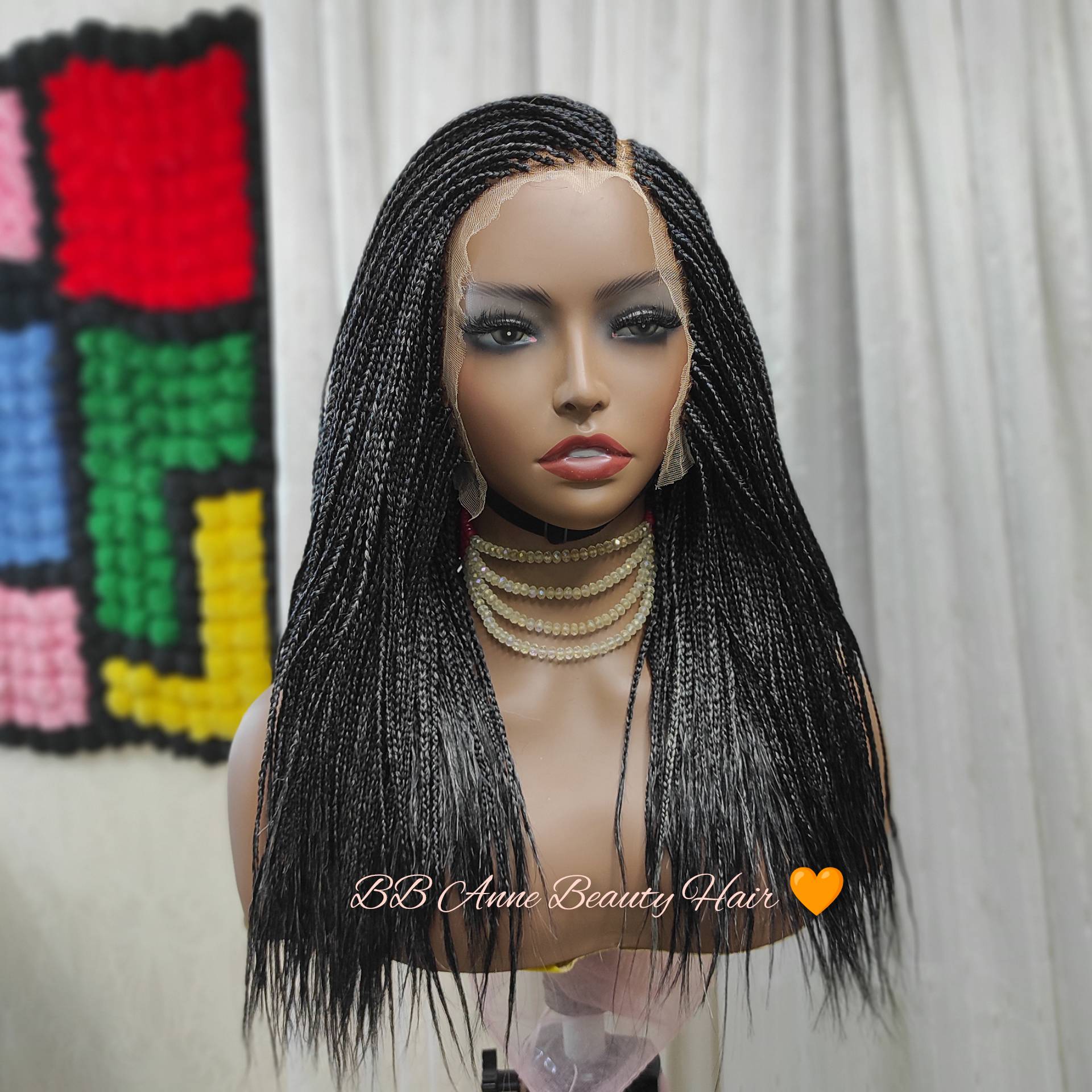 Mannequin head with braided wig and colorful background