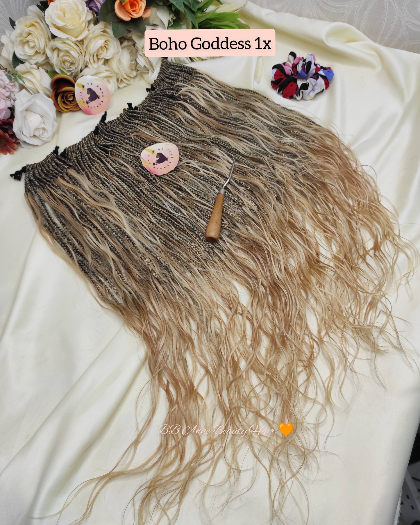 Brown and blonde ombre hair extension with a comb on a white surface, surrounded by flowers.