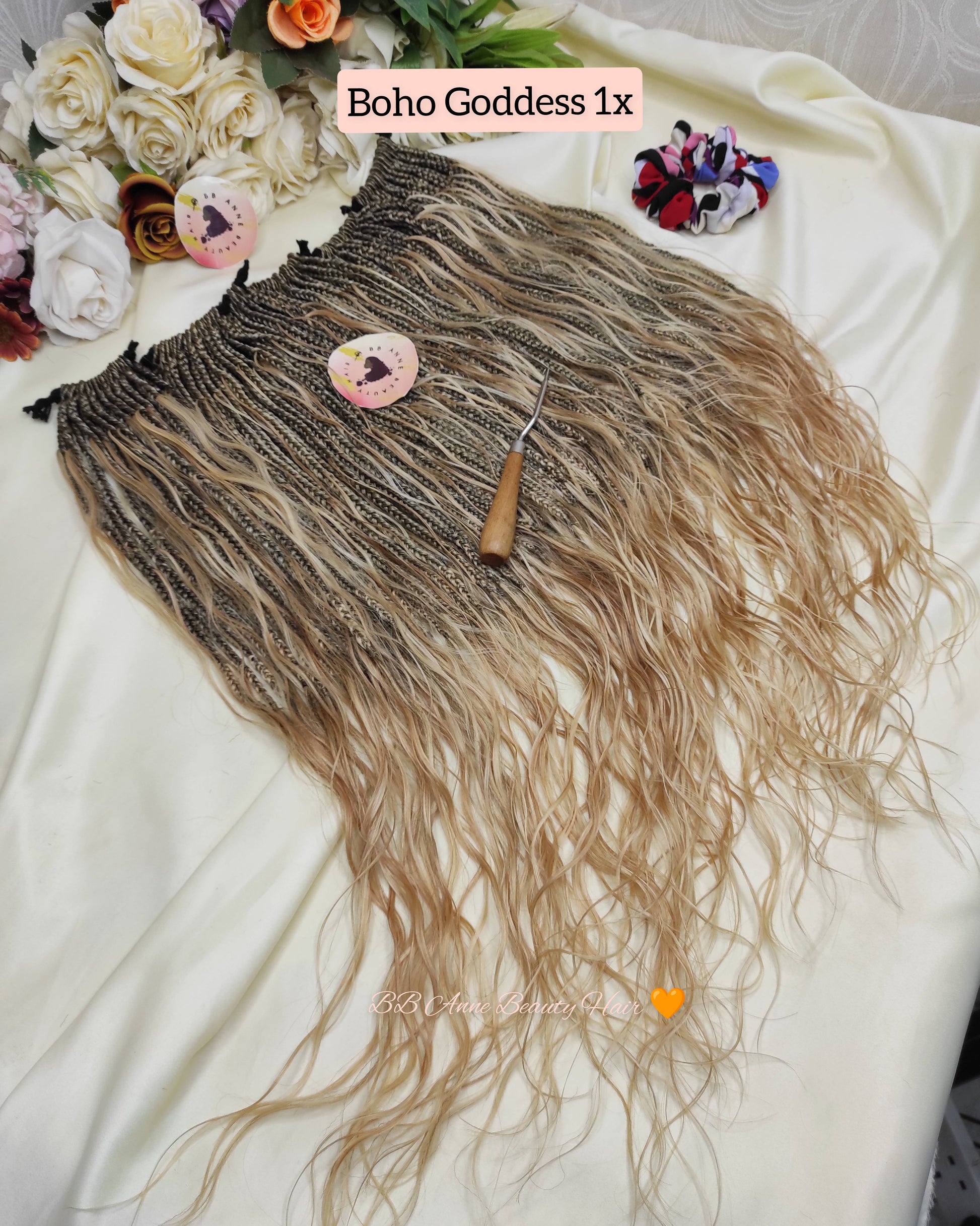 Brown and blonde ombre hair extension with a comb on a white surface, surrounded by flowers.