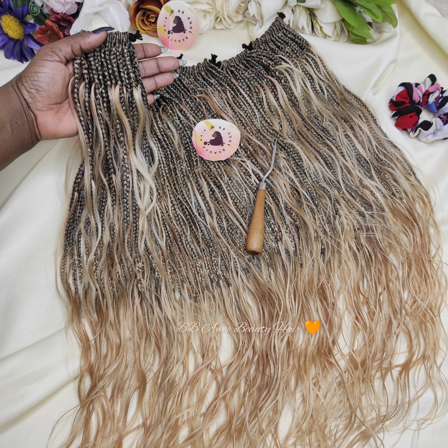 Hair extensions with a comb on a white surface with decorative elements.