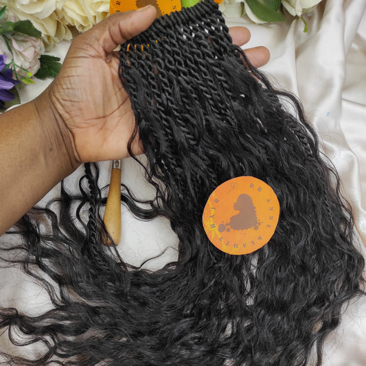 Black curly hair extension held by a hand with a decorative headband featuring an African map design.