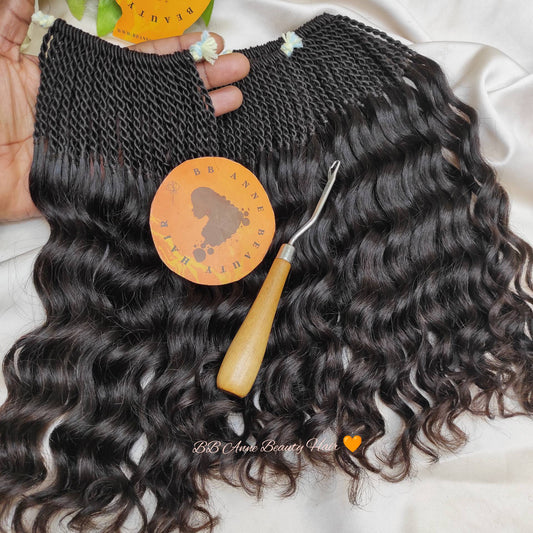 Black wavy hair extensions with a lace closure, a comb, and a branding sticker on a white background.